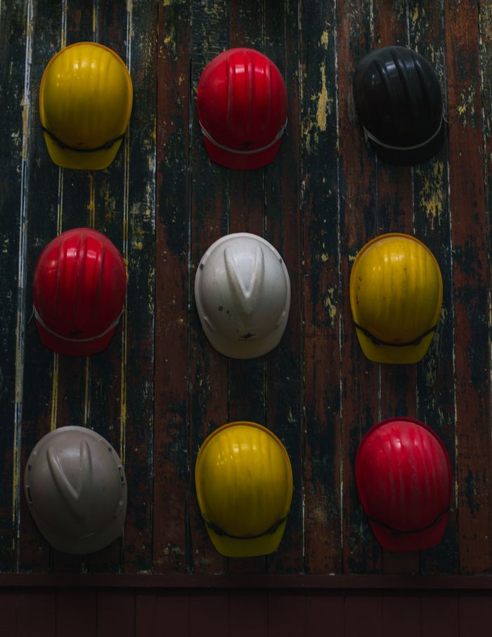 A collection of vibrant hard hats showcased on a textured wooden surface.