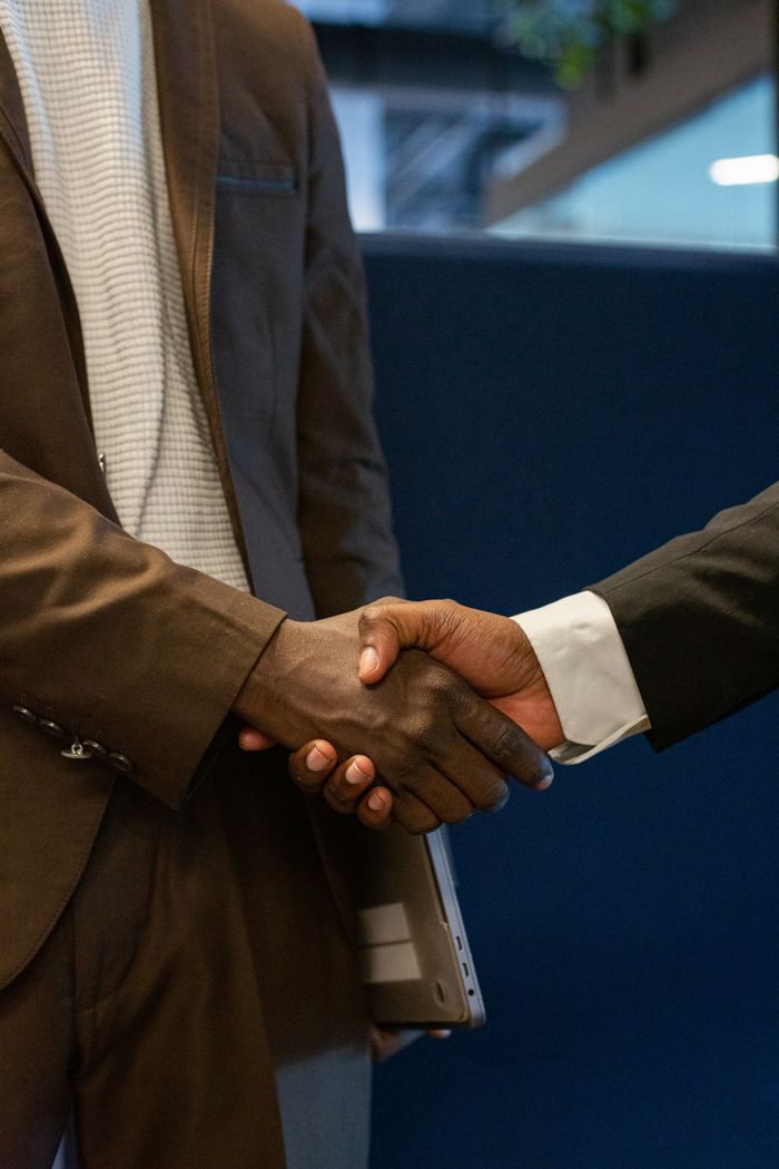 services-03 Close-up of two business professionals shaking hands, symbolizing a successful partnership.